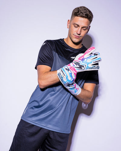 man wearing kaliaaer pink blue and black strapless goalkeeper gloves