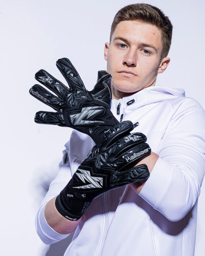 man wearing black and silver kaliaaer goalie gloves