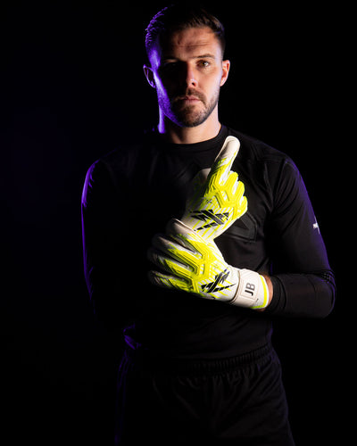 Person wearing goalkeeper gloves on a black background