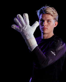 Person wearing white Kaliaaer Jack Butland junior goalie gloves