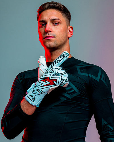 Person with 1 finger up, wearing kaliaaer junior red and black goalkeeper gloves