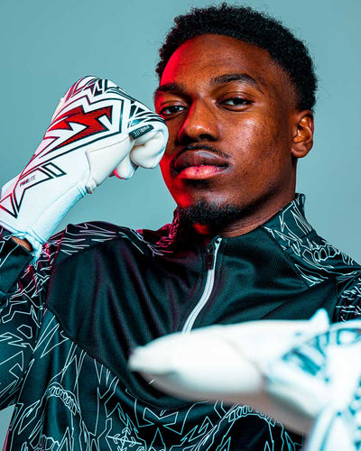 Man pointing wearing kaliaaer red and black goalkeeper gloves