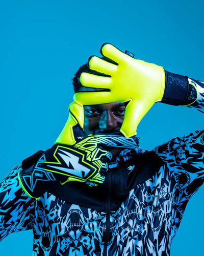Person wearing Kaliaaer Junior Ignite yellow Goalkeeper Gloves