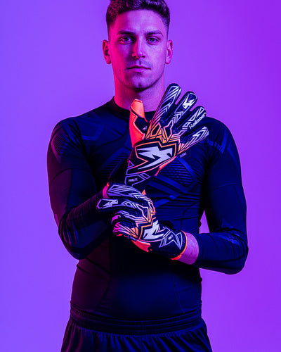 Person wearing Kaliaaer ignite orange junior goalkeeper gloves