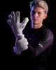 Person wearing a white goalkeeper glove with a logo on a black background