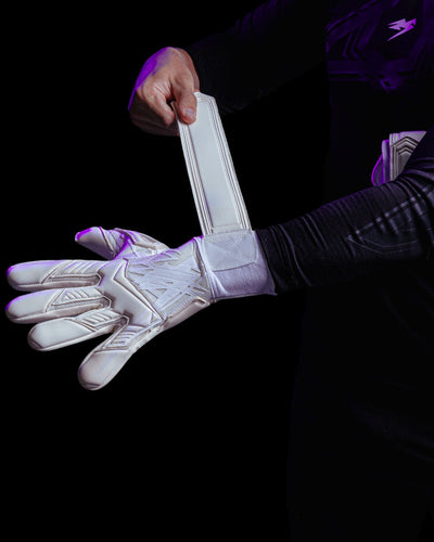 A person fastening the wrists of Kaliaaer white goalkeeper gloves