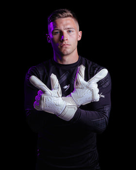 A person shows the backhand of the Kaliaaer nitropro goalkeeper gloves on white colourway