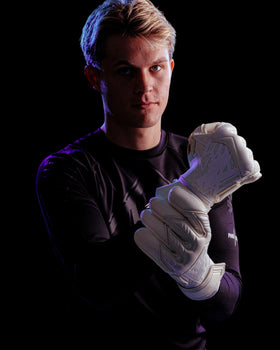 A person wearing Kaliaaer white goalie gloves