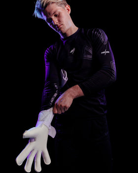 A person putting on kaliaaer PWRpro goalkeeper gloves