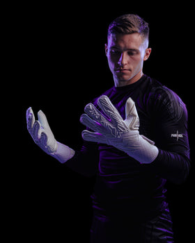 A person looking at the palms of the kaliaaer white goalkeeper gloves
