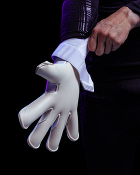 A person putting on Kaliaaer white goalkeeper gloves