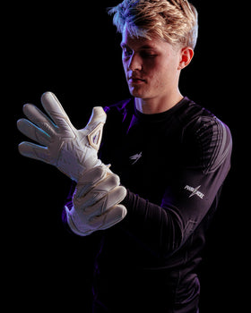 A person showing the backhand of Kaliaaer white goalkeeper gloves with latex knuckles