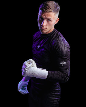A person with fist clenched while wearing kaliaaer PWR pro goalkeeper gloves