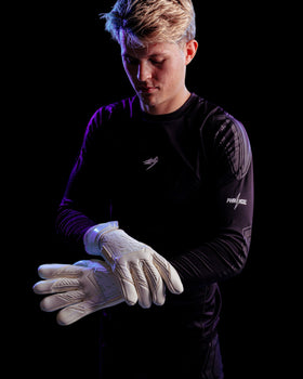 A person wearing the kaliaaer white out goalkeeper gloves