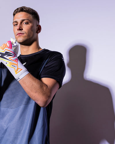 man wearing pink and Neo strapless goalkeeper gloves