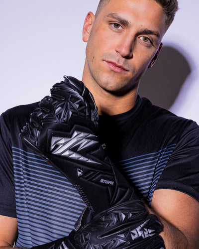 man wearing strapless black and silver goalkeeper gloves