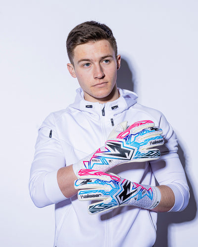 man wearing Kaliaaer pink blue and black strapless goalkeeper gloves