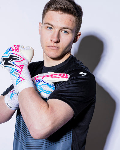 man wearing kaliaaer pink blue and black goalkeeper gloves