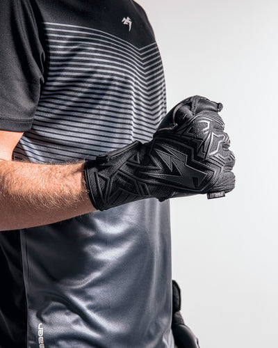 person with fist clenched wearing black goalkeeper gloves