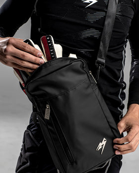 A person putting goalkeeper gloves into the Kaliaaer Pro Glove bag.
